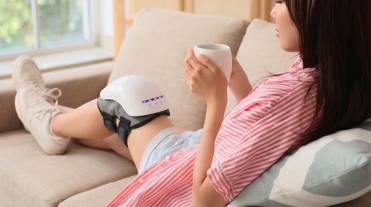 Person relaxing on a sofa while wearing the VO25 knee massager